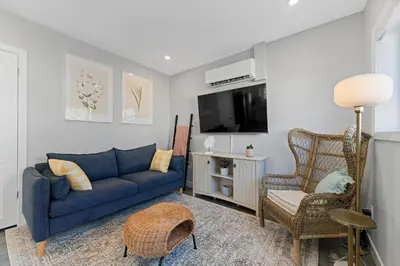 a living room with a blue couch and a tv at The Garden Retreat in Welland, On - 1BR,Free Parking and Workspace in Welland