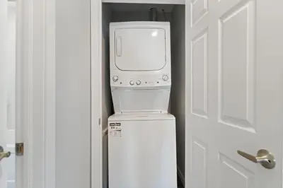 a computer on top of a refrigerator next to a door at The Garden Retreat in Welland, On - 1BR,Free Parking and Workspace in Welland