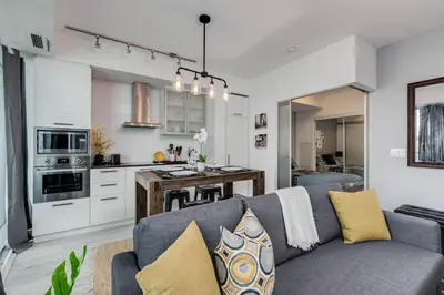 a living room with a couch and a kitchen at RivetStays - The York in Toronto