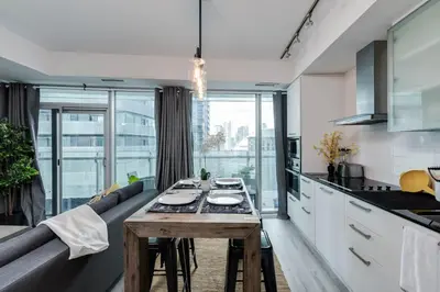 a kitchen and living room with a couch and a table at RivetStays - The York in Toronto