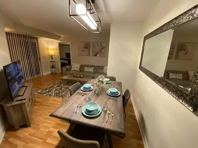 a dining room with a table and a living room at Alaa Aldahhan in Mississauga