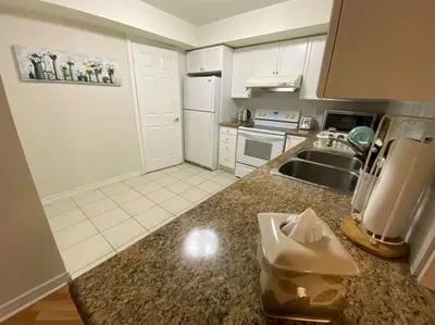 a kitchen with white cabinets and a counter top at Alaa Aldahhan in Mississauga