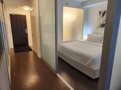 a bedroom with a bed and a door to a hallway at Queen St West Haven - Modern Loft, Downtown Toronto, Free Parking in Toronto