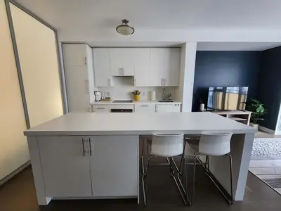 a kitchen with a white counter and white cabinets at Queen St West Haven - Modern Loft, Downtown Toronto, Free Parking in Toronto