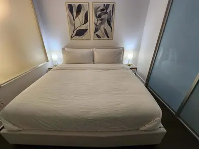 a bedroom with a large white bed with two lamps at Queen St West Haven - Modern Loft, Downtown Toronto, Free Parking in Toronto