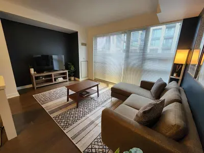a living room with a couch and a tv at Queen St West Haven - Modern Loft, Downtown Toronto, Free Parking in Toronto