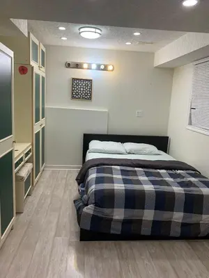 a bedroom with a bed with a plaid blanket at Lower Unit Entire Apartment in Cambridge