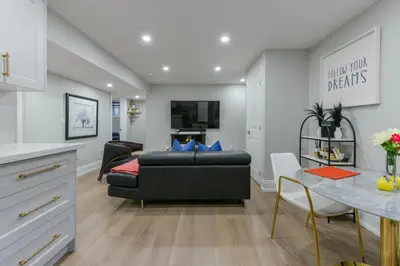 a living room with a black couch and a table at 2 Bedroom Private Suite-Parking-Near Hospital and Airport in Oakville
