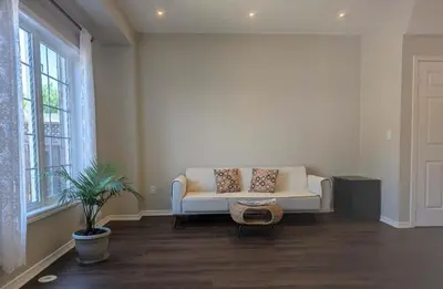 a living room with a white couch and a window at \u65b0\u58f9\u5bb6\u6c11\u5bbf202 in Markham