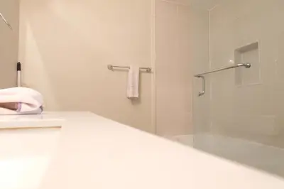 a white bathroom with a shower and a bath tub at \u65b0\u58f9\u5bb6\u6c11\u5bbf202 in Markham