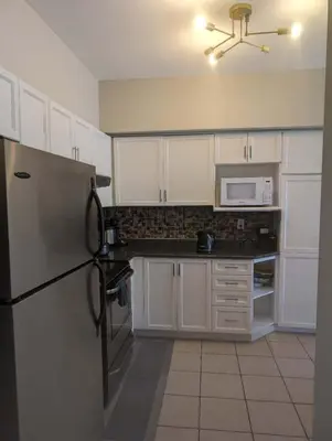 a kitchen with white cabinets and a refrigerator at \u65b0\u58f9\u5bb6\u6c11\u5bbf202 in Markham