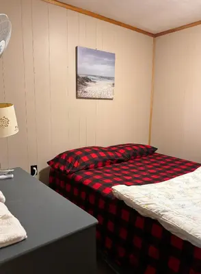 a bedroom with two beds and a picture of the beach at Lakefront Hideaway Resort 10 Total cabins-Lake View, Private Beach in Kawartha Lakes