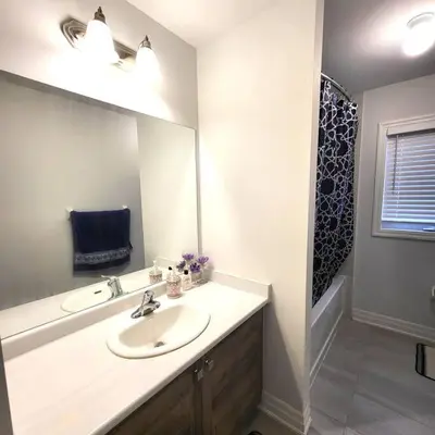 a bathroom with a sink and a large mirror at Spacious 4 Bedroom House in Angus in Angus