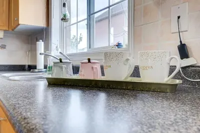 a kitchen counter with three coffee mugs on a tray at Brampton Retreat - Quiet 2BR Residential Area in Brampton