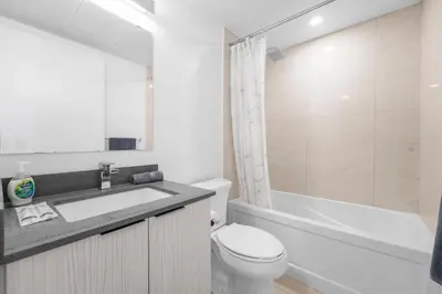 a bathroom with a toilet and a sink and a tub at RentX Downtown 2-Bed Suite Gym WiFi in Toronto