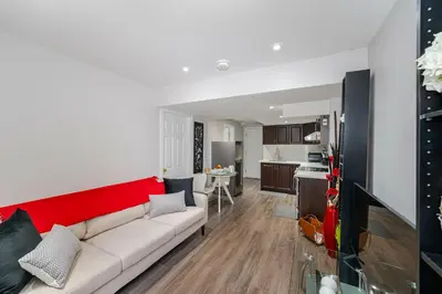 a living room with a couch and a kitchen at Lovely Cozy Apartment in Brampton