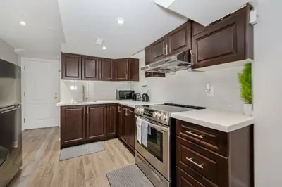 a kitchen with wooden cabinets and a stove top oven at Lovely Cozy Apartment in Brampton