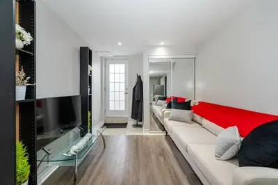 a living room with a couch and a tv at Lovely Cozy Apartment in Brampton