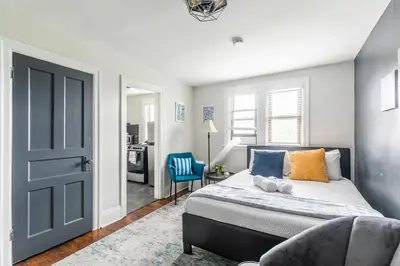 a bedroom with a bed and a blue door at Newly Renovated Modern Studio on James St South in Hamilton
