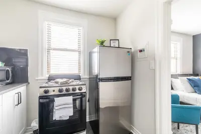 a kitchen with a refrigerator and a stove at Newly Renovated Modern Studio on James St South in Hamilton