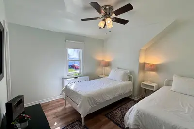 a bedroom with two beds and a ceiling fan at Near the Falls Two Bedroom - 5 min Walk to Clifton in Niagara Falls
