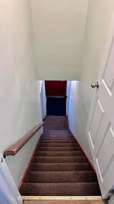 a stairway leading up to a room with a door at Near the Falls Two Bedroom - 5 min Walk to Clifton in Niagara Falls