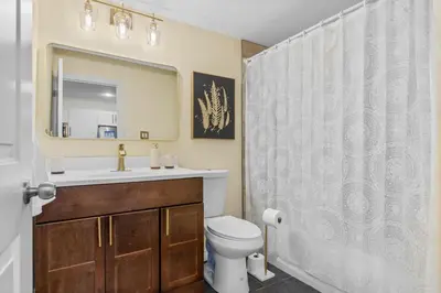 a bathroom with a sink and a toilet and a mirror at Elegant & Private Apartment - Short Walk From Downtown in London