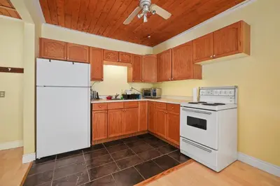 a kitchen with a white refrigerator and wooden cabinets at Marmora and Lake Inn Apartment-Sleeps 5 guests in Marmora