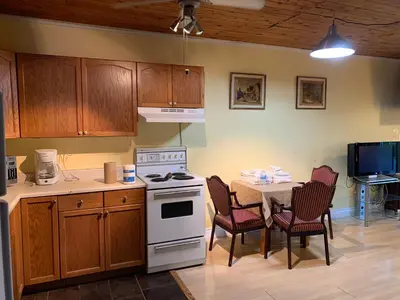 a kitchen with a stove and a table with chairs at Marmora and Lake Inn Apartment-Sleeps 5 guests in Marmora