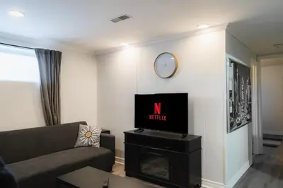 a living room with a couch and a clock on the wall at Modern & Spacious 2BR 2BA Suite All Amenities Included in Brampton