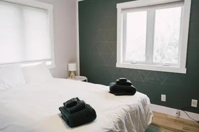 a bedroom with a bed with two bags on it at Sandbanks Cottage on Sheba's Island - 5 min drive, pet friendly in West Lake