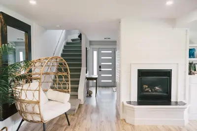 a living room with a fireplace and a chair at Sandbanks Cottage on Sheba's Island - 5 min drive, pet friendly in West Lake