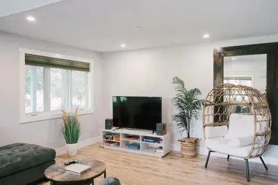 a living room with a tv and a chair at Sandbanks Cottage on Sheba's Island - 5 min drive, pet friendly in West Lake