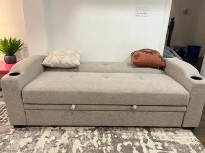 a couch in a living room with two pillows on it at cozy private guest suite in Richmond Hill
