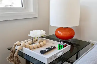 a table with a lamp and a remote control on it at The Garden Suite in London, On 1BR, 1B with free washer and dryer in London