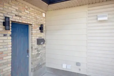 a blue door on the side of a brick wall at Haven Suite in London, On 2Br, 1Bath with free washer and dryer in London
