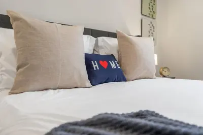 a white bed with pillows on top of it at Haven Suite in London, On 2Br, 1Bath with free washer and dryer in London