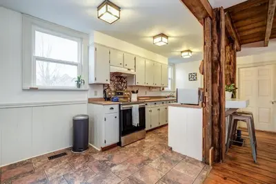 a kitchen with white cabinets and a large window at The Marigold PEC Family Farmhouse country escape in West Lake