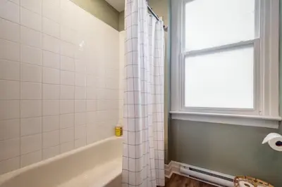 a bathroom with a tub and a shower curtain at From HGTV Marigold Suite in county farmhouse in West Lake
