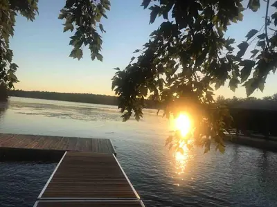 a dock on a lake with the sun setting at Waterfront Cottage - Fireplace - Kawartha in Lakefield