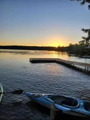 a blue kayak on the water near a dock at Waterfront Cottage - Fireplace - Kawartha in Lakefield