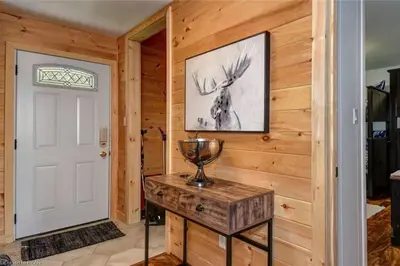 a room with a white door and a wooden wall at Waterfront Cottage - Fireplace - Kawartha in Lakefield