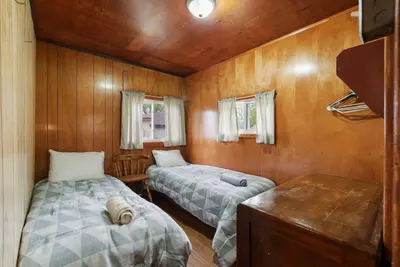 two beds in a room with wooden walls at Dive into Nature at Rice Lake in Bailieboro