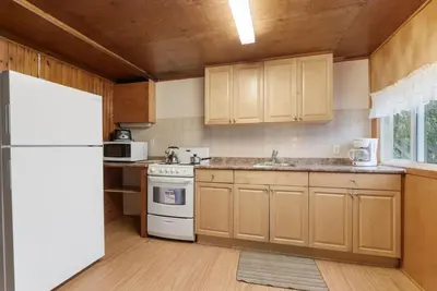 a kitchen with wooden cabinets and a white refrigerator at Dive into Nature at Rice Lake in Bailieboro