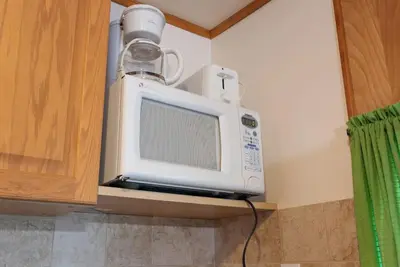 a microwave with a cup on top of it in a kitchen at Enjoy The Outdoors at Rice Lakes in Bailieboro