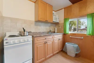 a kitchen with wooden cabinets and a white stove top oven at Enjoy The Outdoors at Rice Lakes in Bailieboro
