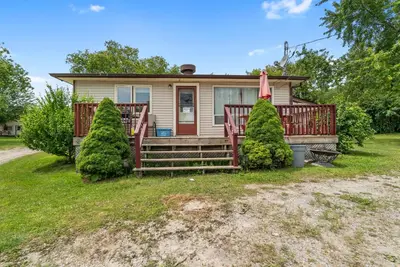 a small house with a porch and two trees at Beautiful Lake Views in Nature in Bailieboro