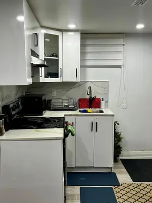 a kitchen with white cabinets and a sink at Brand new single unit guest basement apartment in Mississauga