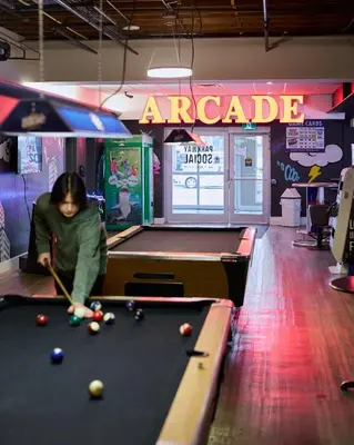 a woman playing a game of pool at an arcade at Staybridge Suites St. Catharines Conf Ctr by IHG in St. Catharines