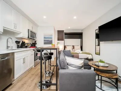 a kitchen and living room with a couch and a table at Cozy Studio Apt - Corktown Hamilton - Near DT in Hamilton